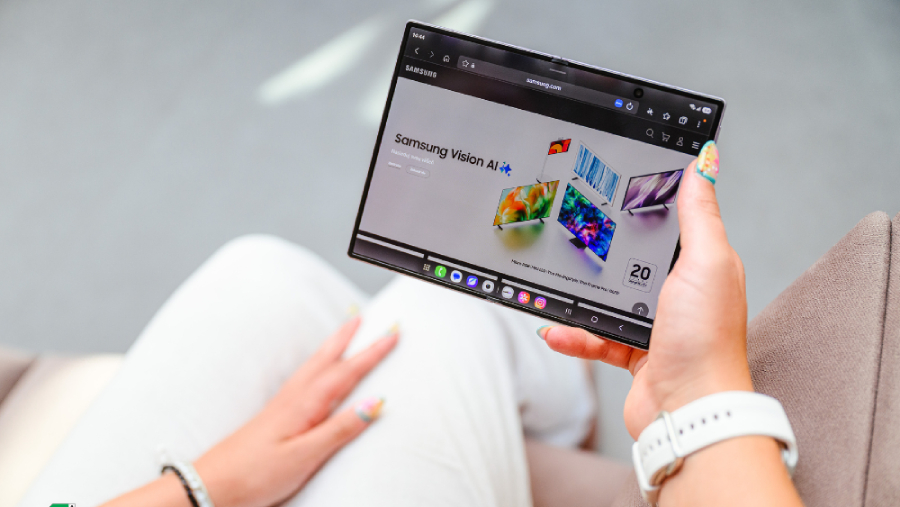 Pohled shora na plně rozložený ohebný displej telefonu Samsung Galaxy Z Fold8 v ruce uživatelky, která si prohlíží webové stránky Samsung Vision AI.