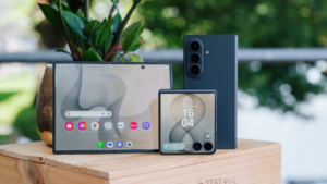 Tři skládací smartphony Samsung Galaxy – otevřený telefon s velkým displejem, zavřený véčkový telefon s vnějším displejem zobrazujícím hodiny a stojící smartphone viditelný zezadu s trojitým fotoaparátem.